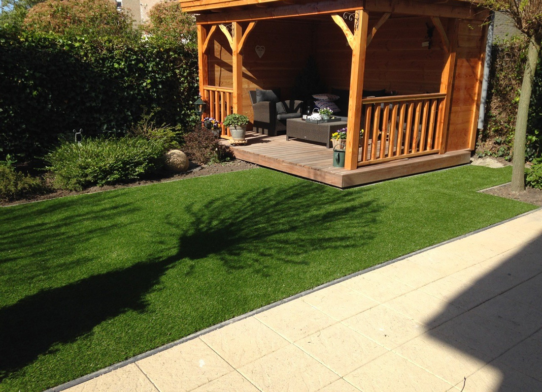 Kies kunstgras met een natuurlijke uitstraling in een tuin met veel sierplanten en bloemen.