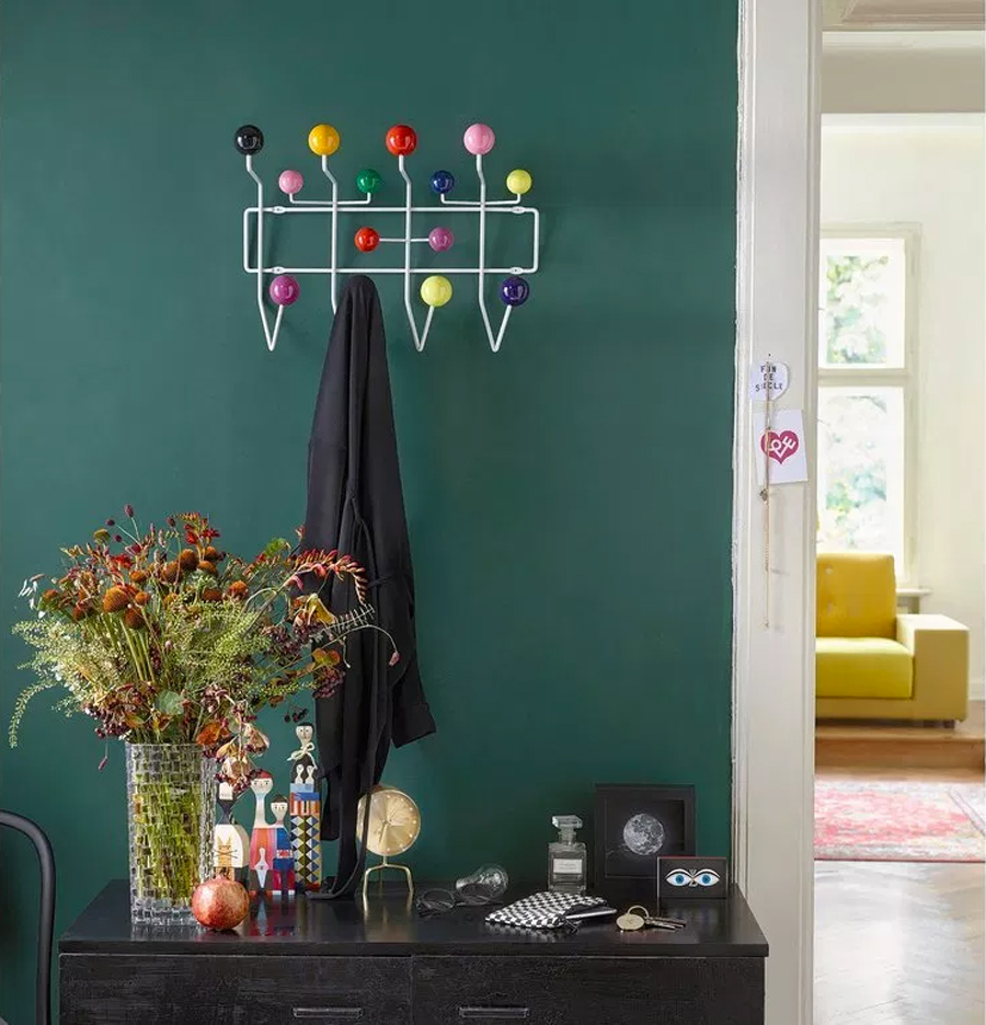 Groen gekleurde muur met de Vitra Eames designkapstok Hang it all. 