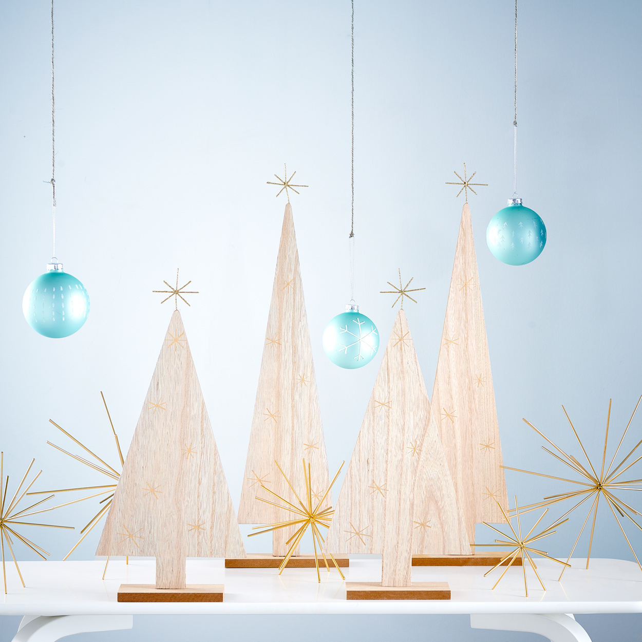 Houten kerstboomvormen met blauwe accessoires en trendy kerststerren. 