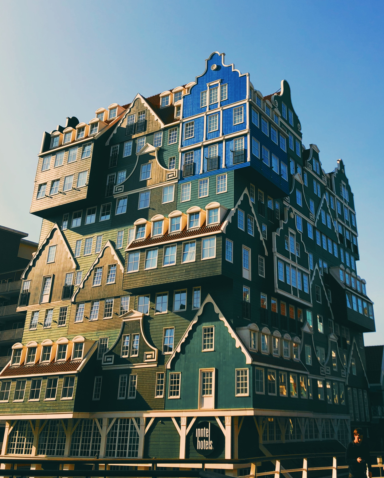 Het moderne Inntel Hotel in Zaandam met en groengekleurde kappen en gevels met witte lijsten en kozijnen in oude stijl.