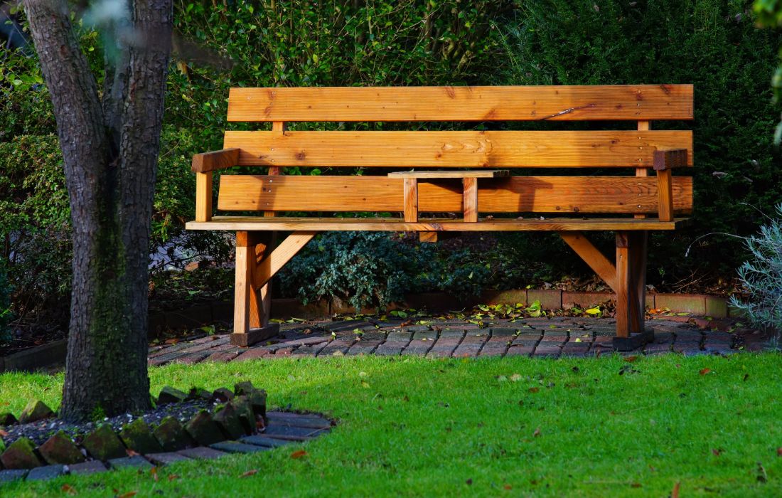 Een tuinbank met ingebouwde tafel bespaart ruimte.