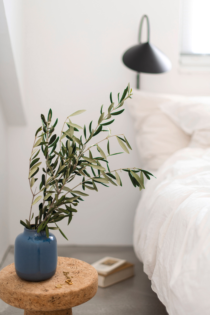 Vergroen je slaapkamer met groene takken in een bloemenvaas voor op je slaapkamer.