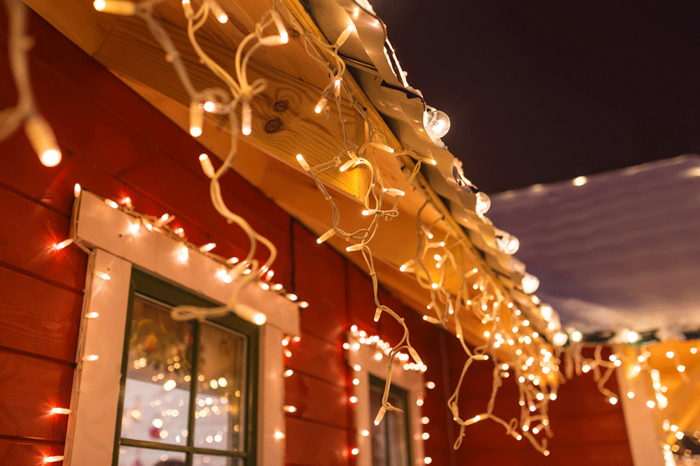 Kerstverlichting langs het dakrand geeft een sfeervol effect aan het huis.