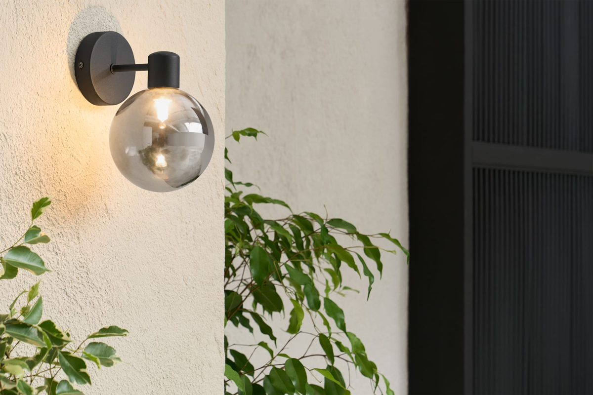 De bol van rookglas in combinatie met zwart armatuur is de perfecte buitenlamp voor aan de wand van jouw moderne tuin. 