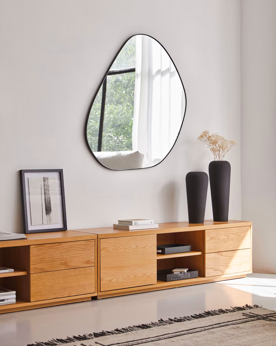 Voor compacte slaapkamers is de Anera wandspiegel perfect. De organisch gevormde spiegel met afgeronde hoeken en ronde lijnen heeft een subtiele rand van zwart metaal. Deze muurspiegel verhoogt het licht en het gevoel van ruimtelijkheid. 