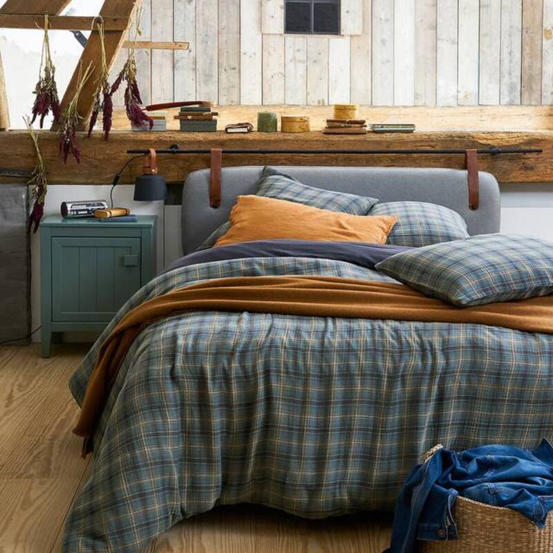 Het blauwe dekbedovertrek met ruit staat hartstikke goed bij de grof houten elementen in je landelijke slaapkamer. 