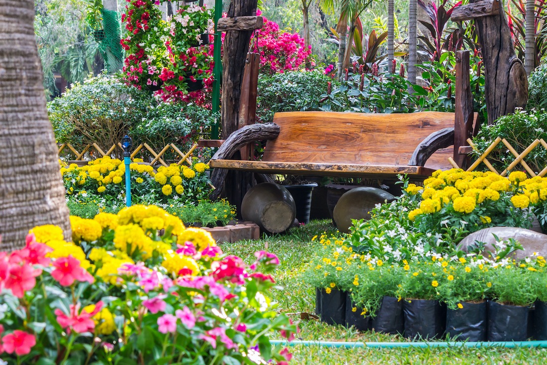 woonhome-tuin-vol-kleurrijke-bloemen-planten-houten-bank-tuinbank-1