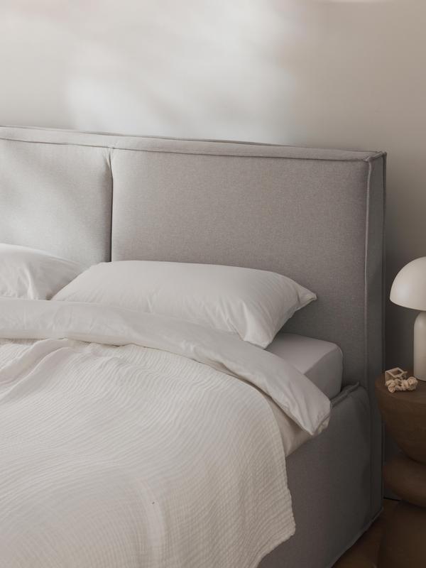 Dit lichtbeige bed genaamd DREAM ziet er luxe uit dankzij de stoffering. En je ziet het van de buitenkant niet, maar je kunt dankzij de opklapbare lattenbodem je seizoensdekbed, kussens en nog veel meer opbergen.